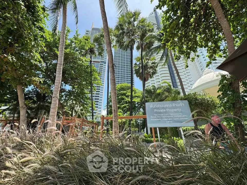 Luxurious high-rise building surrounded by lush tropical gardens and palm trees, offering a serene urban oasis.
