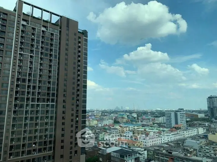 Stunning cityscape view from high-rise building with clear blue sky.