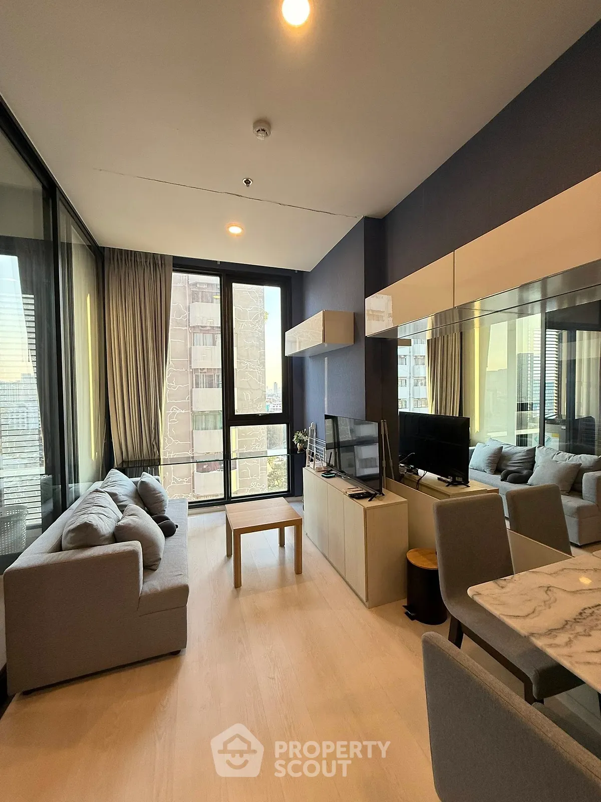 Modern living room with city view, stylish furniture, and natural light