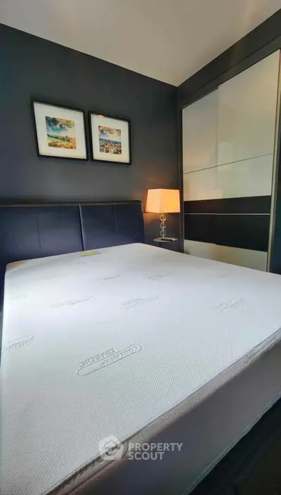 Modern bedroom with stylish decor and comfortable mattress in a sleek apartment.