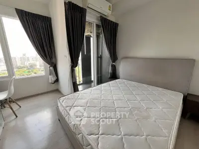 Modern bedroom with large windows and city view, featuring a comfortable bed and stylish decor.