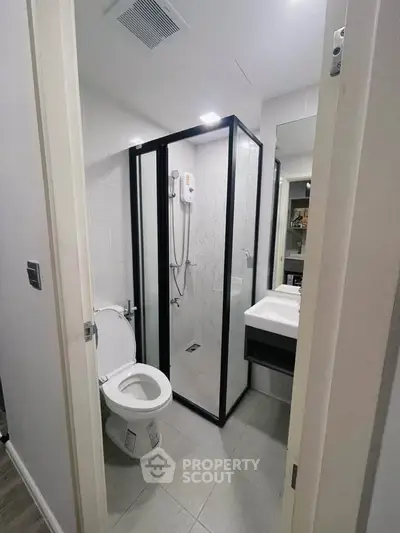 Modern bathroom with glass shower enclosure and sleek fixtures.