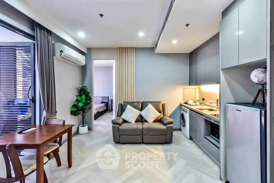 Modern open-plan living room with sleek kitchen and cozy seating area, perfect for urban living.