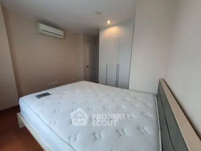 Spacious bedroom with modern air conditioning and ample closet space.