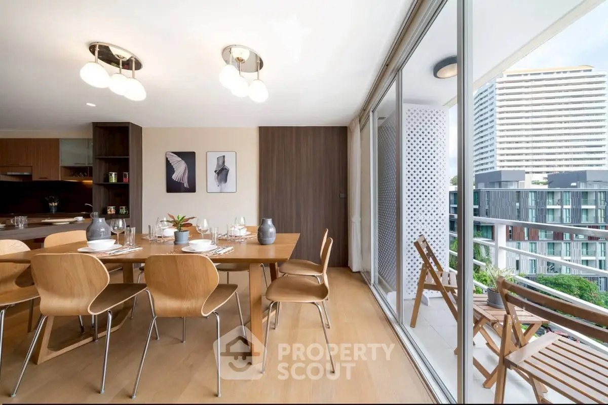 Modern dining area with elegant wooden furniture and balcony view in a high-rise apartment.