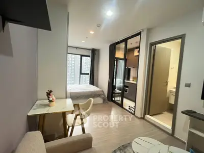 Modern studio apartment with open layout, featuring a cozy living area, compact kitchen, and bright bedroom.