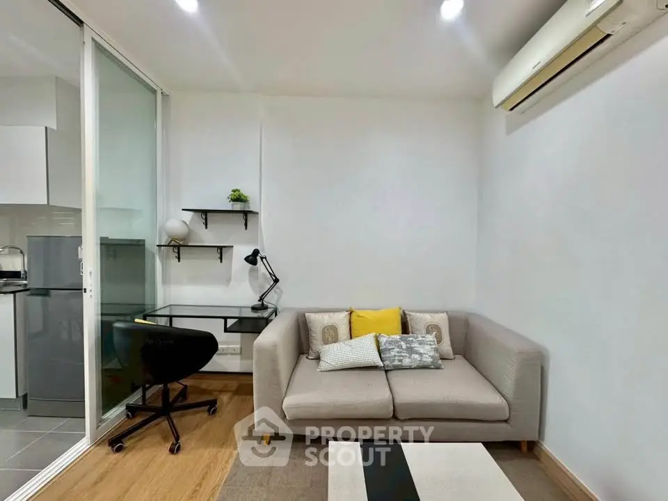 Modern living room with cozy sofa, desk, and air conditioning in a stylish apartment.