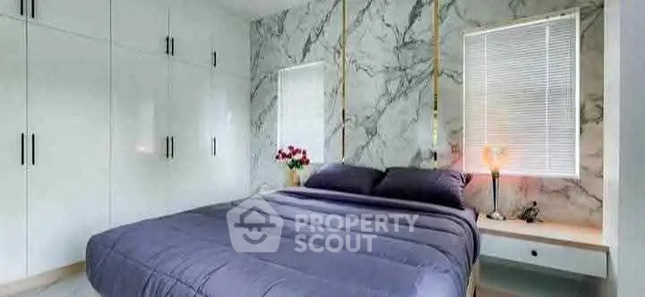 Luxurious bedroom with marble accent wall and modern furnishings