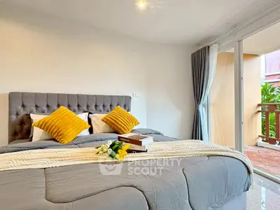 Spacious bedroom with cozy decor and balcony access, perfect for relaxation and comfort.