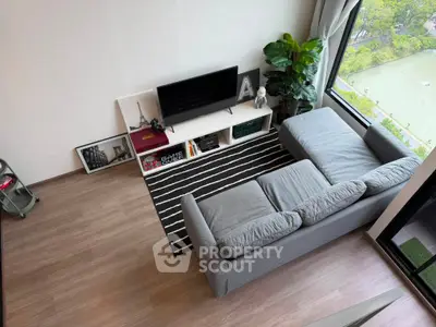 Modern living room with large window and stylish decor overlooking scenic view.