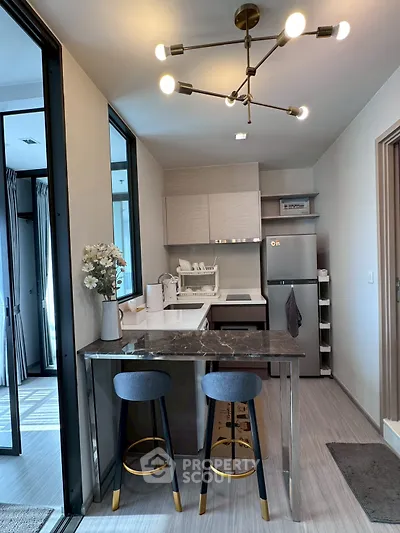 Modern kitchen with sleek design, featuring marble countertop and stylish lighting, perfect for urban living.
