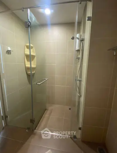 Modern bathroom with glass shower enclosure and sleek tile design.