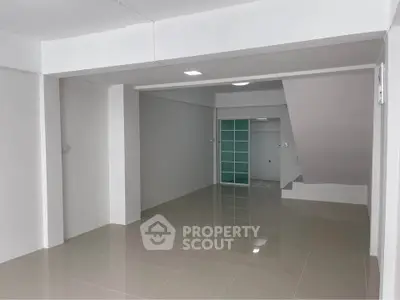 Spacious modern interior with sleek tiled flooring and minimalist design.