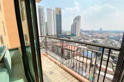 Stunning city view from a high-rise balcony with modern railing and urban skyline.