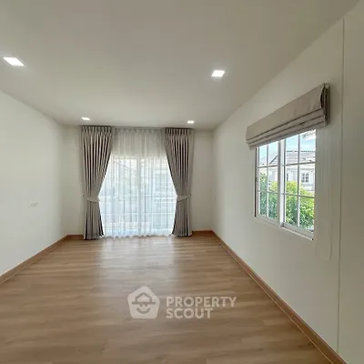 Spacious empty room with large window and elegant curtains, perfect for customization.