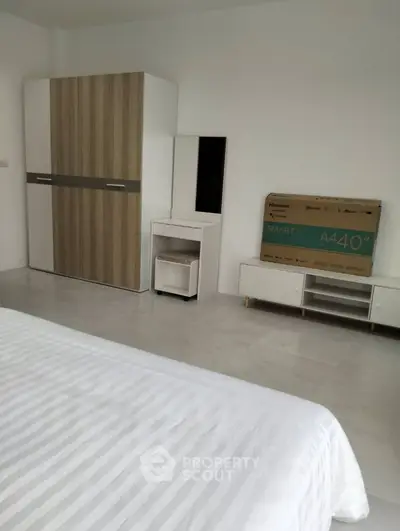Spacious bedroom with modern furniture and smart TV setup