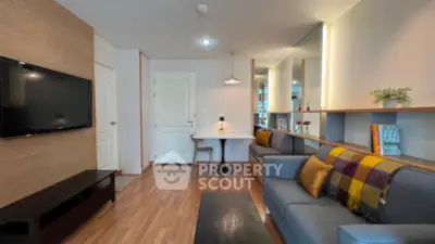 Modern living room with cozy sofa and wall-mounted TV in stylish apartment.