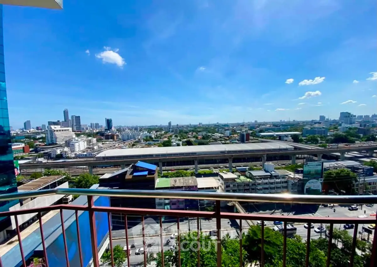 Stunning cityscape view from a high-rise balcony with clear blue skies.