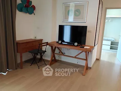 Modern living room with wooden flooring, stylish furniture, and a flat-screen TV for a cozy ambiance.