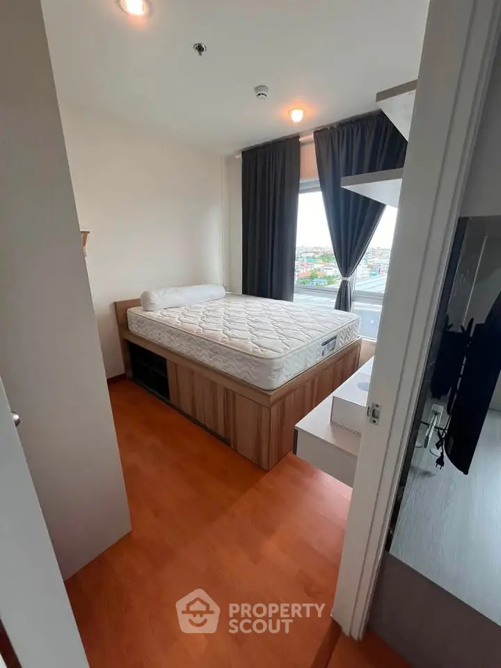 Cozy bedroom with large window and wooden flooring, featuring a comfortable bed and modern decor.