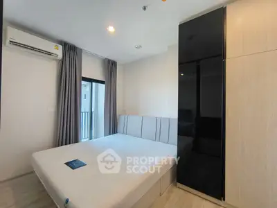 Modern bedroom with sleek wardrobe and air conditioning in a stylish apartment.