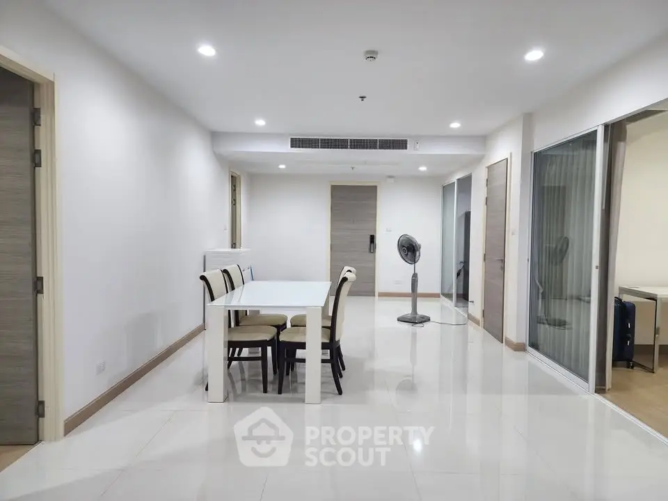Spacious modern dining area with sleek white table and chairs, perfect for family gatherings.