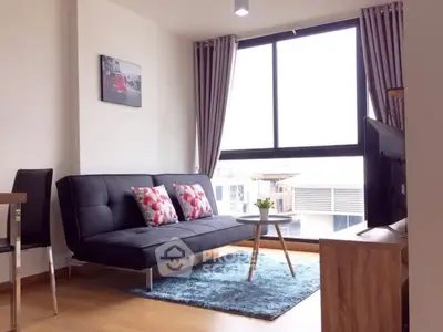 Modern living room with sleek sofa, large window, and stylish decor