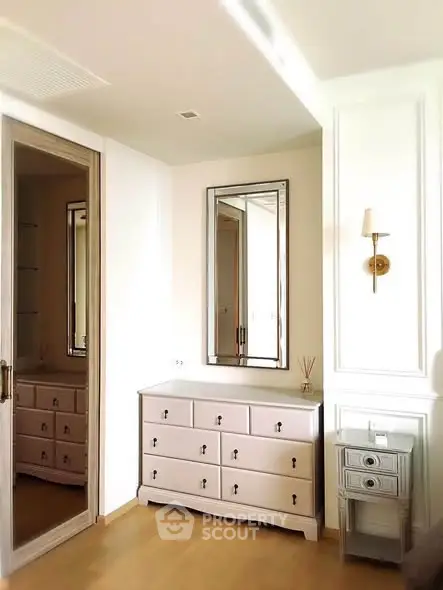 Elegant bedroom corner with mirrored wardrobe and stylish dresser