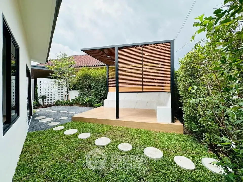 Charming backyard with modern pergola and lush greenery, perfect for outdoor relaxation and entertainment.