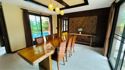 Elegant dining room with wooden table and pool view, perfect for entertaining guests.