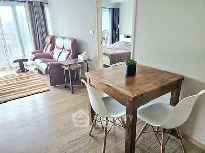 Modern apartment interior with cozy living room and dining area, featuring wooden floors and stylish furniture.