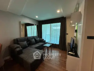 Modern living room with stylish furniture and large window, perfect for relaxation and entertainment.