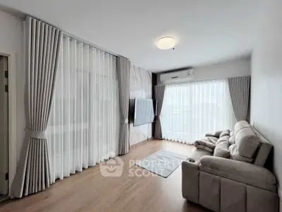 Spacious living room with modern decor and large windows for natural light.