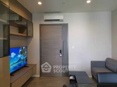 Modern living room with sleek furniture and wall-mounted TV, featuring a minimalist design and neutral tones.