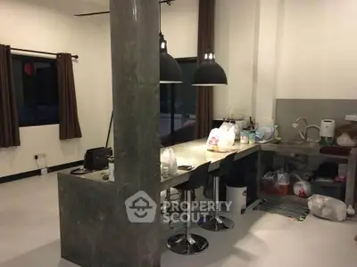 Modern kitchen with concrete island and pendant lighting