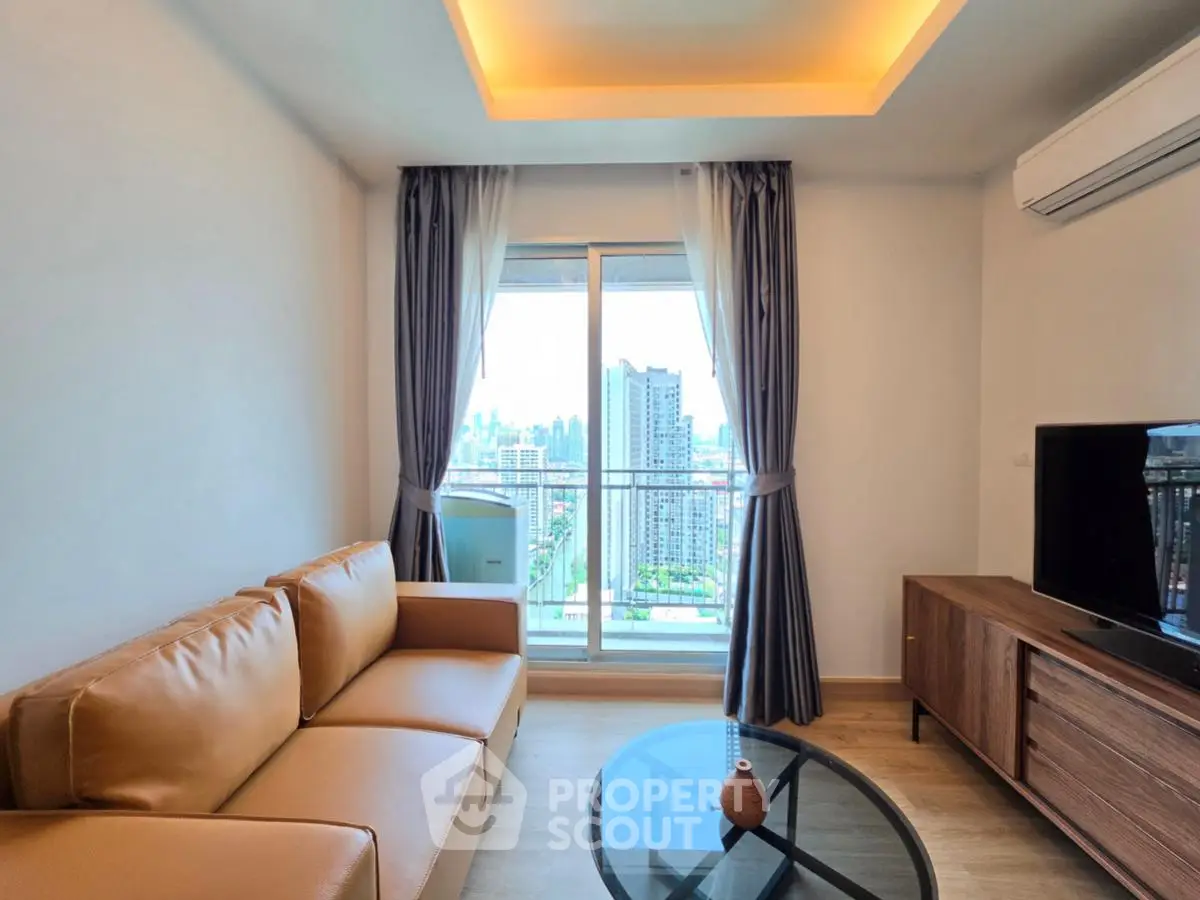 Modern living room with city view, featuring a leather sofa, glass coffee table, and large window.