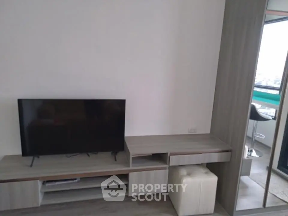 Modern living room with sleek TV stand and mirrored wardrobe, perfect for urban living.
