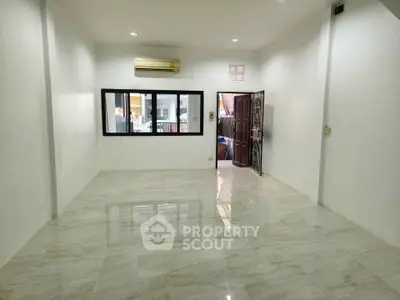 Spacious unfurnished room with marble flooring and large window, perfect for customization.
