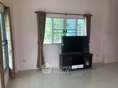 Bright living room with large window and modern TV setup