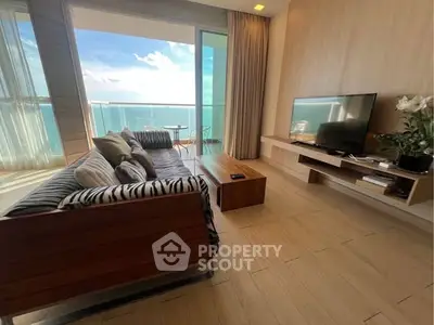 Luxurious living room with ocean view and modern decor in beachfront apartment.