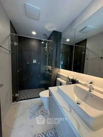 Luxurious modern bathroom with sleek design and spacious shower area.