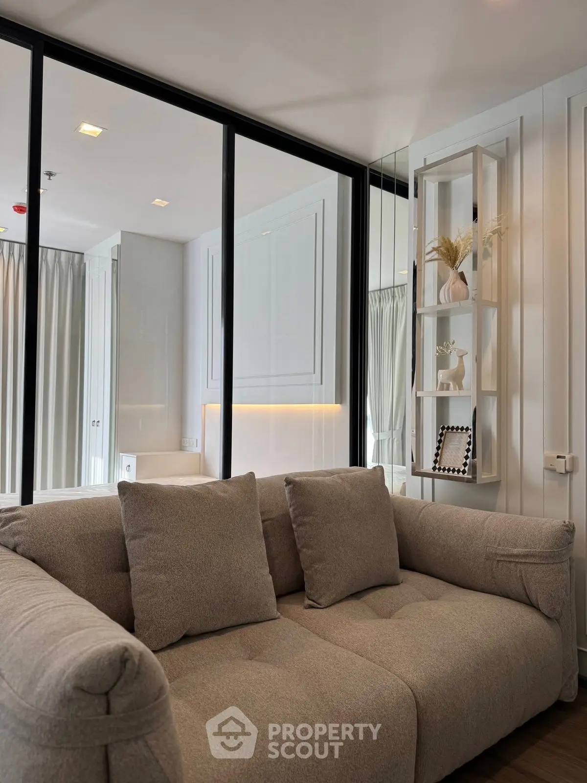 Modern living room with stylish beige sofa and elegant decor in a bright, airy space.