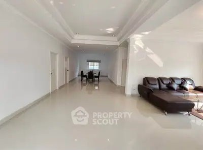 Spacious modern living room with elegant leather sofa and dining area.