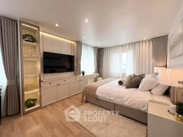 Luxurious bedroom with elegant decor, large windows, and modern furnishings in a serene setting.