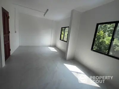 Spacious unfurnished room with large windows and natural light