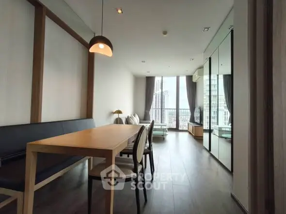 Modern living room with city view, sleek furniture, and floor-to-ceiling windows.