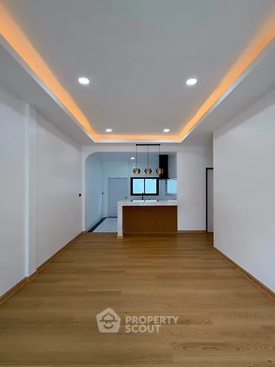 Modern open-plan living room with stylish lighting and wooden flooring