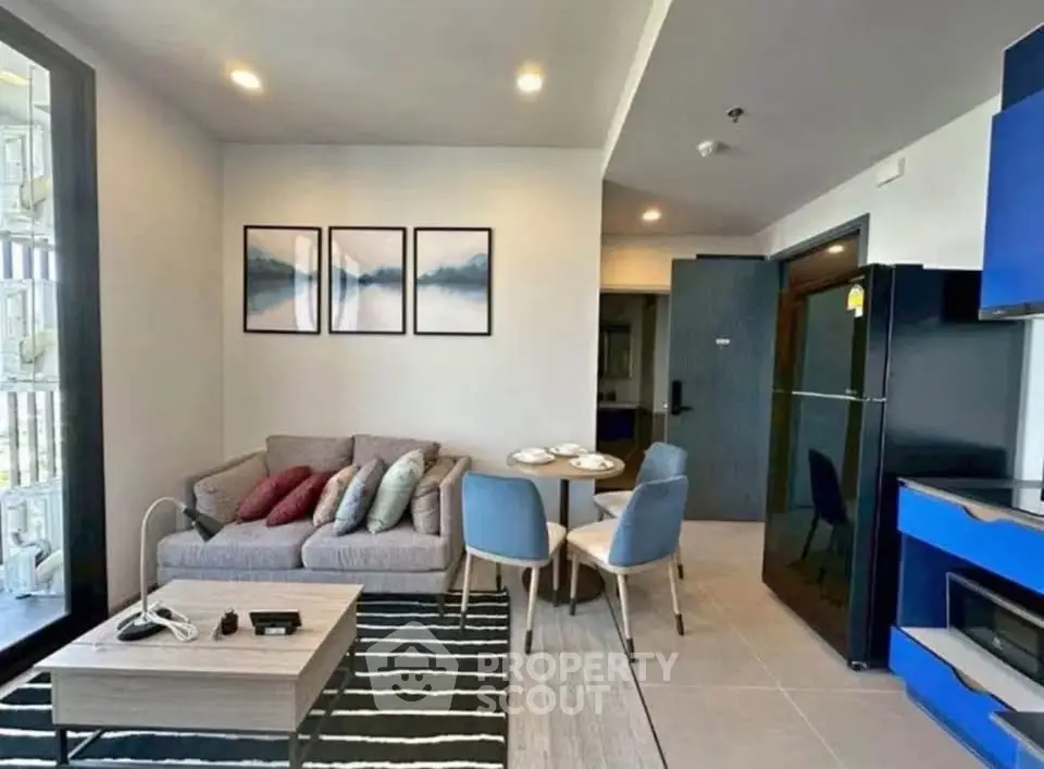 Modern living room with stylish decor and open layout, featuring a cozy sofa and dining area.