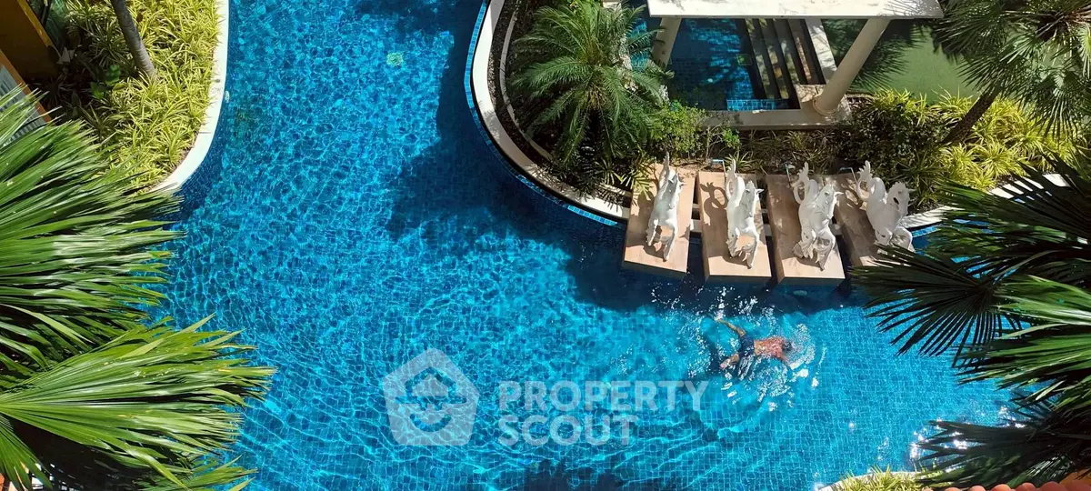 Luxurious swimming pool with tropical landscaping and elegant sculptures in a high-end property.