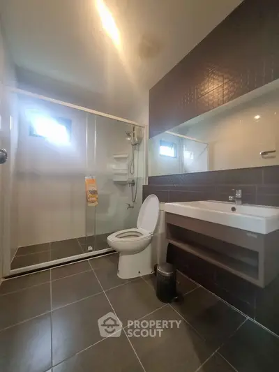 Modern bathroom with sleek design, featuring a spacious shower and contemporary fixtures.